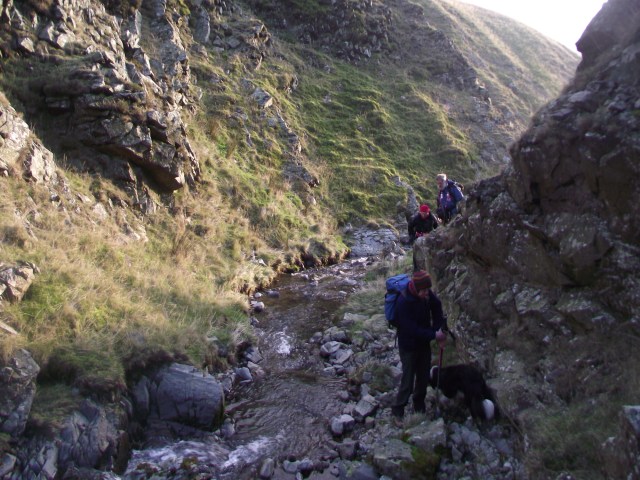 The stream is confined by the steep valley sides